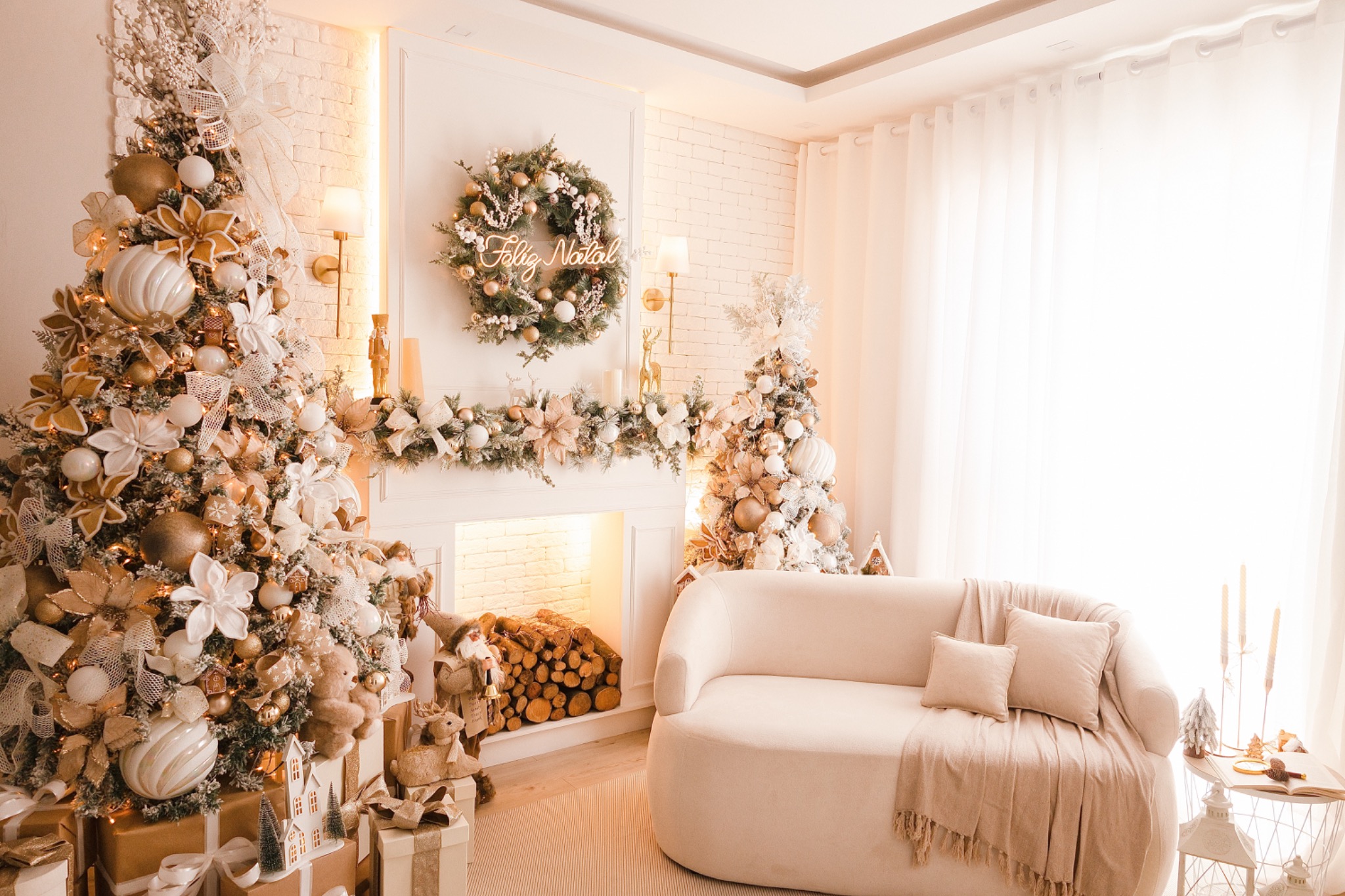 Visão ampla do cenário principal de Natal, com árvores, lareira e sofá claro